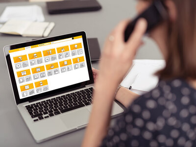 frau im bro schaut auf laptop und telefoniert